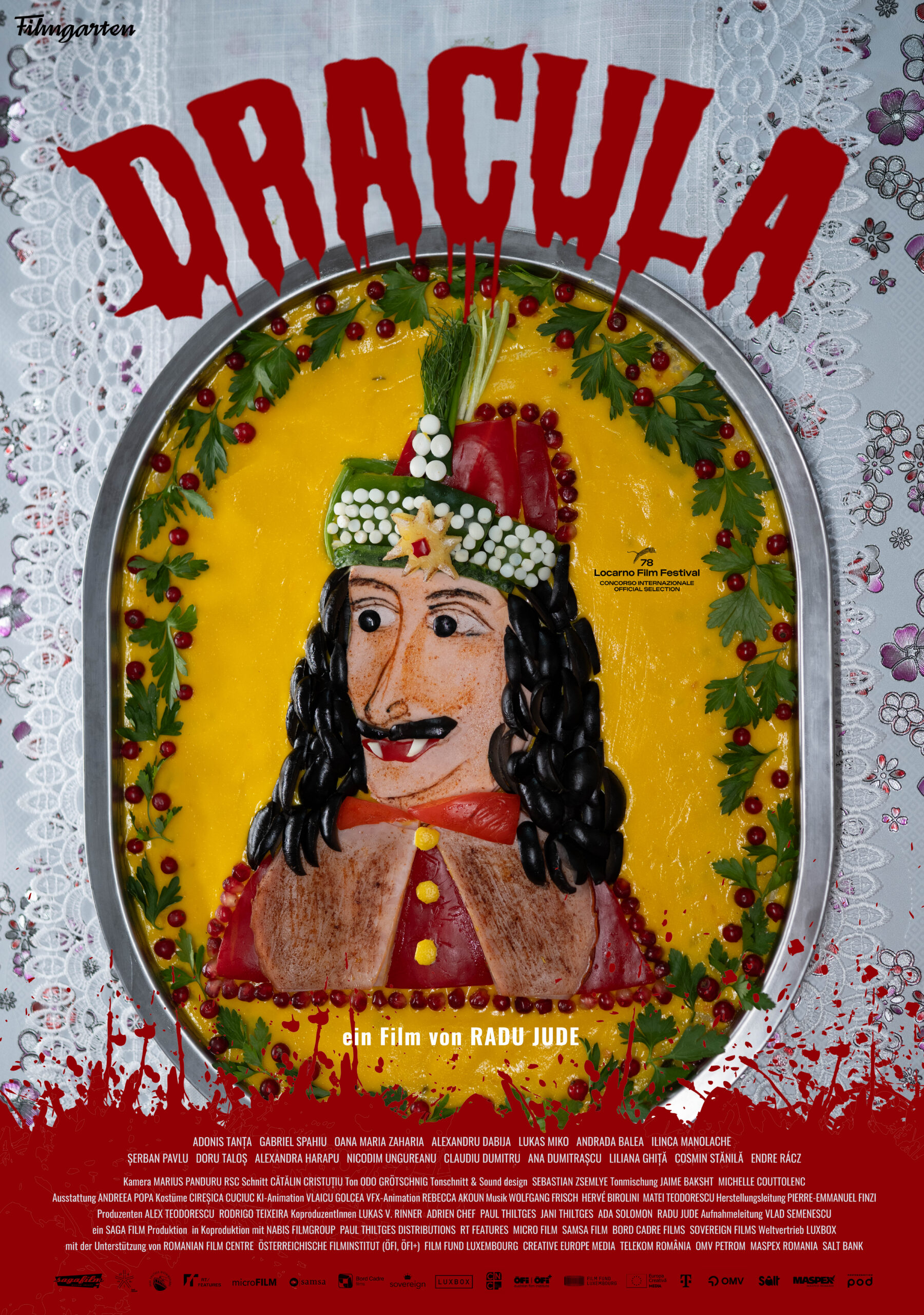 Dargestellt ist eine Torte mit einem Dracula-Porträt, verziert mit Waldfrüchten und Kräutern, umgeben von Tortendeko.