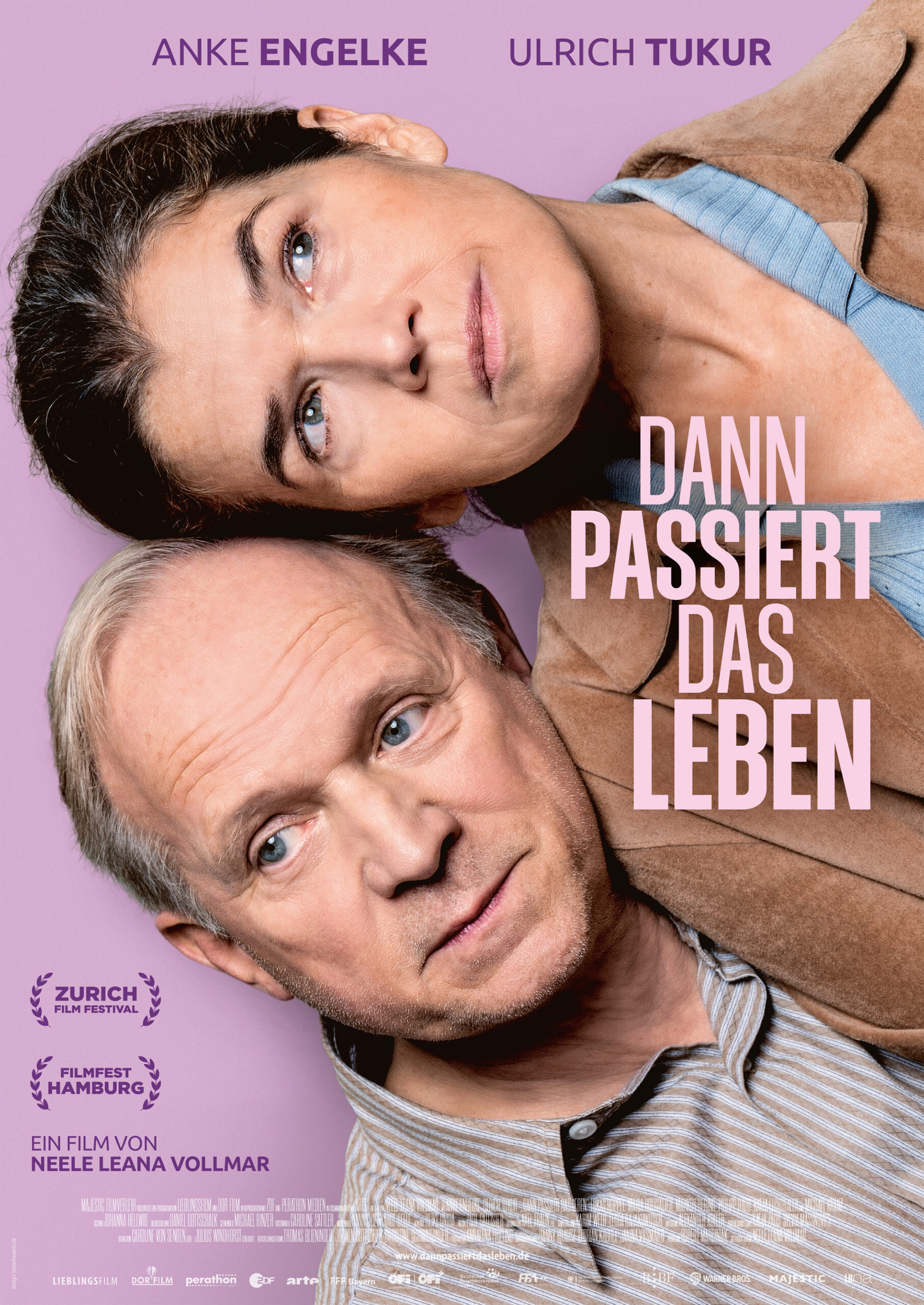 Filmplakat mit einer Frau und einem Mann, beide in Nahaufnahme übereinander liegend, vor lila Hintergrund; darüber die Namen Anke Engelke und Ulrich Tukur sowie der Filmtitel „Dann passiert das Leben“ in großen Buchstaben.