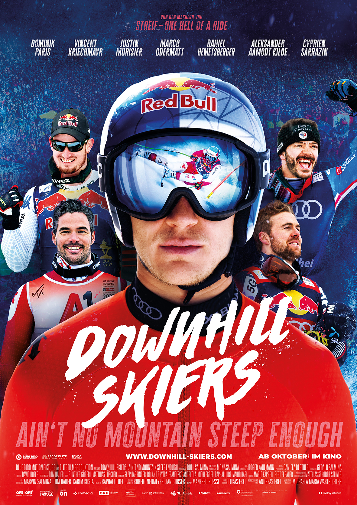 Filmplakat für 'Downhill Skiers' mit mehreren Skifahrern in Ausrüstung, im Mittelpunkt ein Mann mit Helm und Skibrille, in deren Spiegelung ein Skirennen zu sehen ist; oben die Namen von sechs Fahrern, unten der Filmtitel und der Slogan 'Ain't no mountain steep enough'.