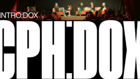 Podiumsdiskussion mit vier Personen auf einer Bühne vor Publikum mit großem, weißem Schriftzug 'CPH:DOX' im Vordergrund und kleineren Texten 'INTRO:DOX' oben links.