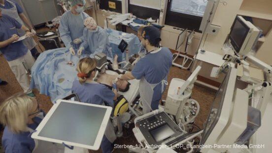Medizinisches Team behandelt einen Patienten in einem OP-Saal mit Monitoren und Geräten